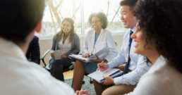 Group of healthcare leadership sitting in a circle smiling