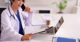 Physician looking at paper and utilizing labor forecasting and per diem staffing to account for busy season.