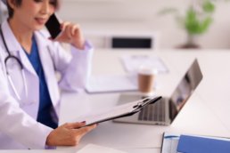 Physician looking at paper and utilizing labor forecasting and per diem staffing to account for busy season.