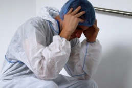 Nurse with head down experiencing burnout
