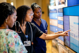 Nurses Collaborate Over Digital AI Training Dashboard